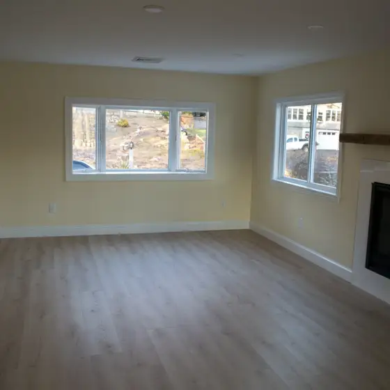 Renovated living room with new hardwood flooring and fireplace