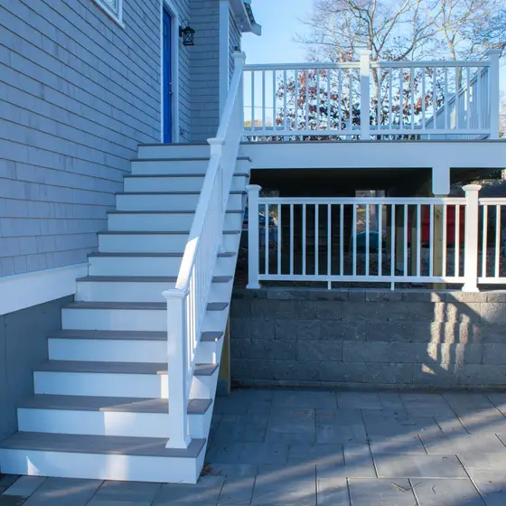Staircase leading up to a deck beside a blue front door