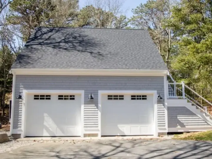 Finished two-car garage with dormer, matching the home's siding
