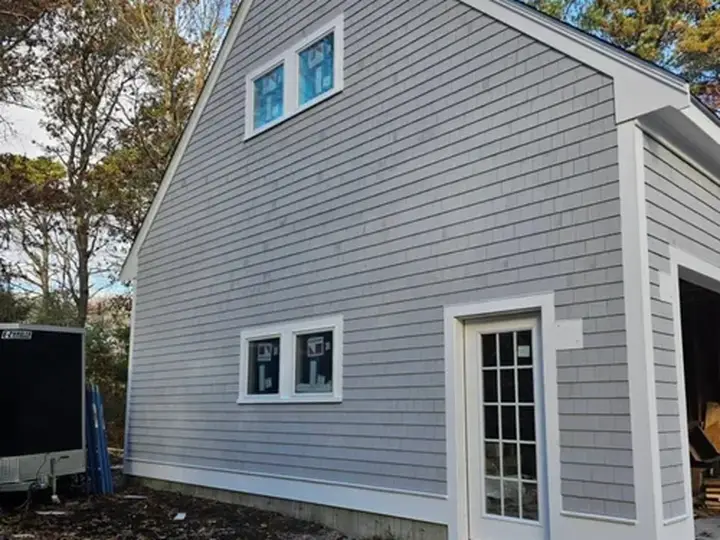 Gray shingle-style siding installation on a Cape Cod home